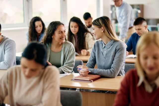 Support worker with student in classroom